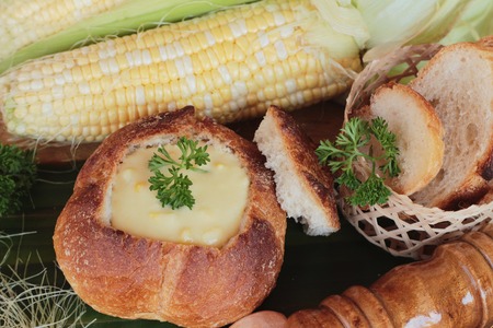 Corn soup in bread bowl with fresh cornの写真素材