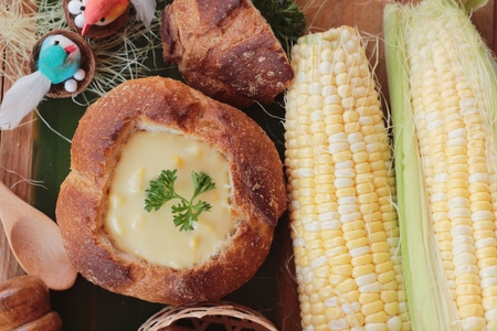 Corn soup in bread bowl with fresh cornの写真素材