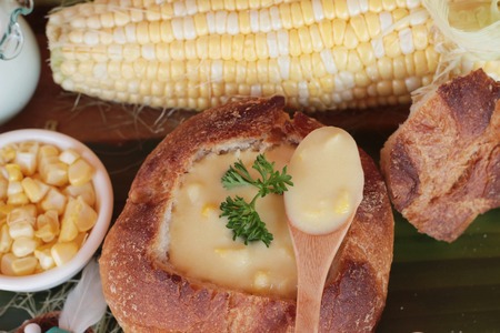 Corn soup in bread bowl with fresh cornの写真素材