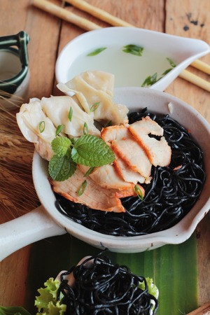 black noodles with pork and dumpling delicious.の写真素材