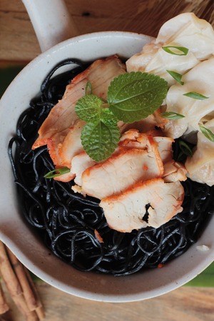 black noodles with pork and dumpling delicious.の写真素材