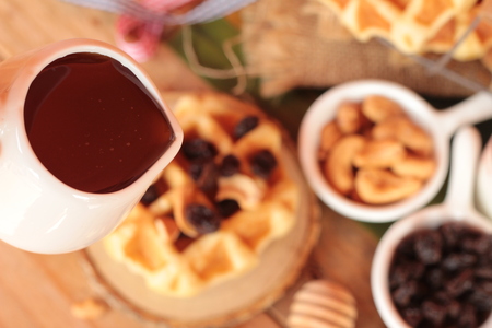 Waffles topped with honey, raisins and cashews.の写真素材