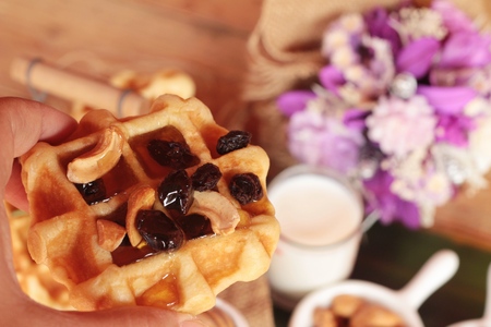 Waffles topped with honey, raisins and cashews.の写真素材