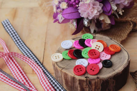 Colorful plastic buttons for sewing on wood backgroundの写真素材