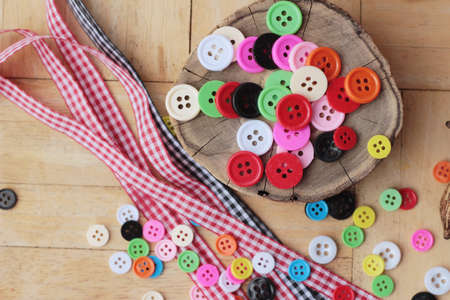 Colorful plastic buttons for sewing on wood backgroundの写真素材