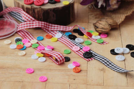Colorful plastic buttons for sewing on wood backgroundの写真素材