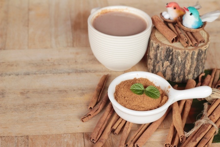 cinnamon powder and sticks on wood backgroundの写真素材
