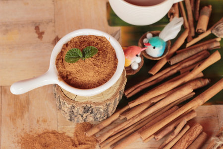 cinnamon powder and sticks on wood background