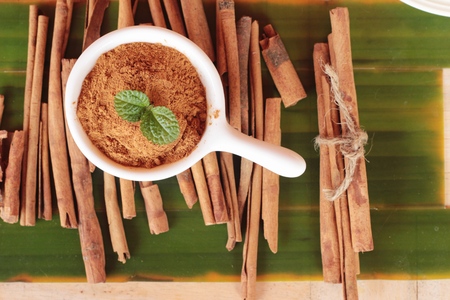 cinnamon powder and sticks on wood backgroundの写真素材