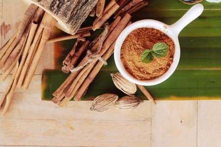 cinnamon powder and sticks on wood backgroundの写真素材