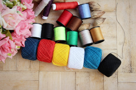 Colorful thread for sewing on wood background