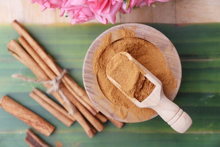 Cinnamon powder and sticks on wood backgroundの写真素材