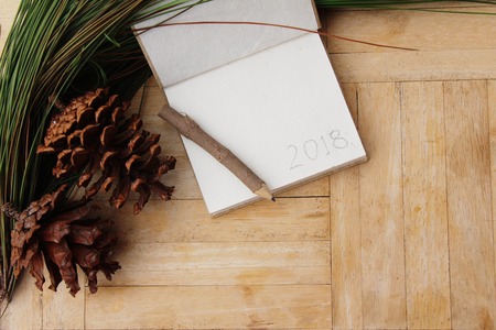 Pine cones and notepad on wood backgroundの写真素材