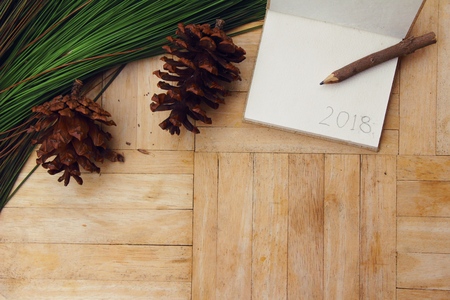 Pine cones and notepad on wood backgroundの写真素材