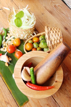 Making spicy papaya salad on wood backgroundの写真素材