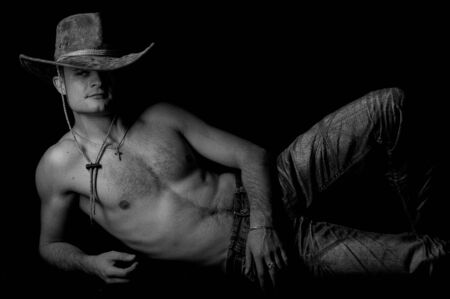 Black and white portrait of a young male lying shirtlessの写真素材