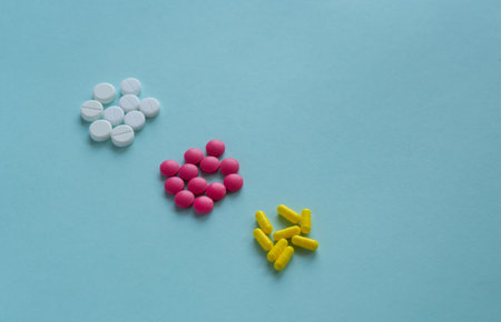 Three types of tablets sorted by color. Three heaps in one diagonal line. White, pink round pills...