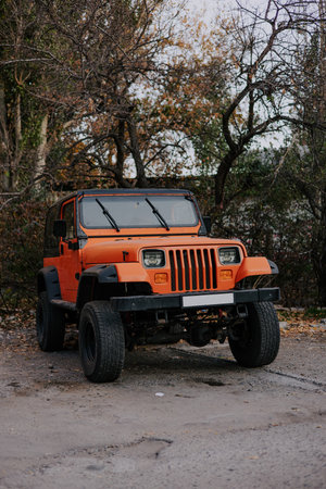 Bishkek, Kyrgyzstan -22 Oct 2023: Old Jeep Wrangler Jedi red orange color in the car park. Two door SUV sport utility vehicleのeditorial素材