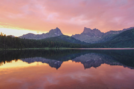 Amazing pink sunset on Svetloye lake. Ptitsa and Zvezdnyy peaks in mountain nature park Ergaki, Krasnoyarsk region, Siberia, Russiaの写真素材