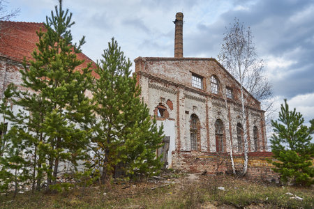 Abandoned destroyed brick building with high chimney. Old facility industrial premises, Glass...