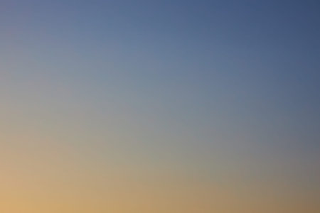 Gradient from blue to yellow. Cloudless clear sky at sunset, background. Natural gradient wallpaper