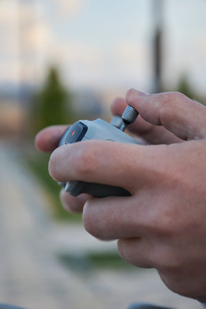 Male hands hold a drone control panel, close-up. Management by quadcopter flight and videotaping...