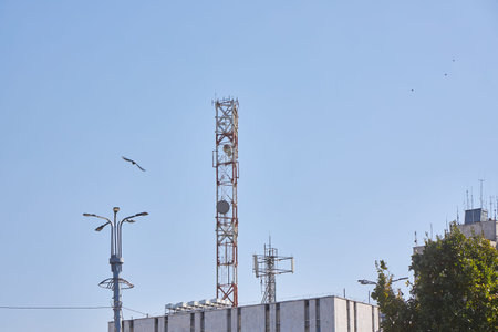 Many different antennas on the old roof of a multi-story residential building, blue sky, copy space....