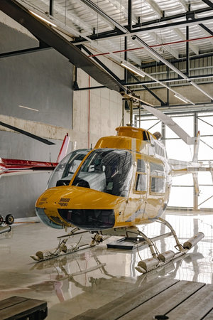 Yellow tourist helicopter in hangar, rotary-wing aircraft