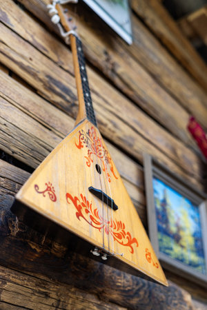 Ethnic musical instrument balalaika hanging on wooden wall. selective focus.の写真素材