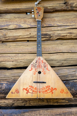 Ethnic musical instrument balalaika hanging on wooden wall.の写真素材