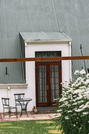 Outdoor furniture, table and two chairs near exit from house to backyard. Wooden glass doorの写真素材