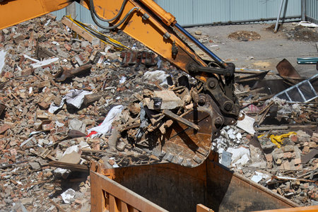 The excavator bucket is filled with construction waste, close-up.
