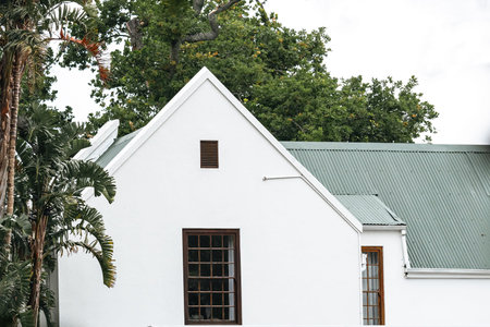 portion of a residential building classic architectural style. white facade, green roof. Large...