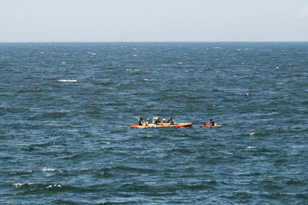 Group of people kayaking in open ocean on a sunny day, summer adventure. Outdoor water sport...