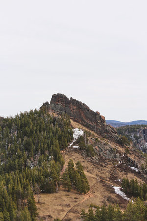 Mountain landscape with coniferous forest and rock formation under cloudy sky. Nature travel for adventure outdoor. Beautiful scenery. Takmak rock, Stolby Krasnoyarskの写真素材