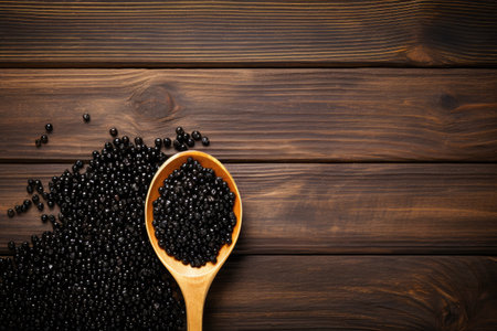 Black caviar in a spoon on a wooden background. Copy space for textの素材