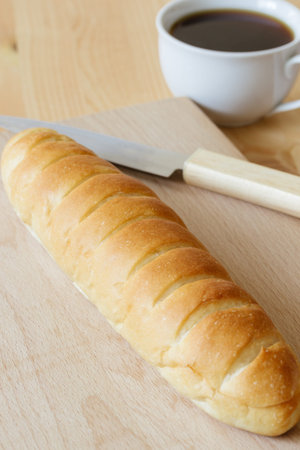 bread with knife on a wooden board