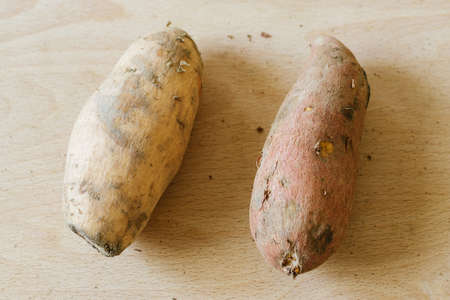 sweet potatoes on wooden backgroundの写真素材