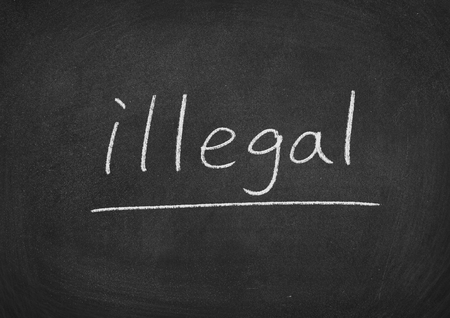 illegal concept word on a blackboard backgroundの写真素材