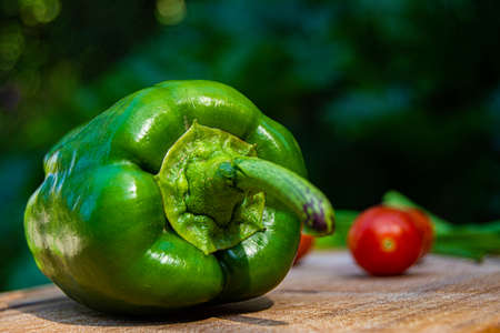 green bell pepper on wood with tomatoes backgroundの写真素材