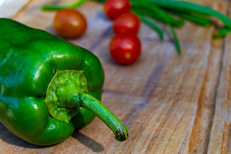 green bell pepper on wood with tomatoes backgroundの写真素材