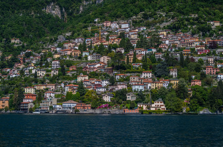 lake Como has beautiful housing and estates surrounded by lush forrest and mountains.の写真素材