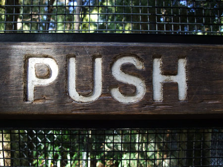 A wooden push sign panel  on door