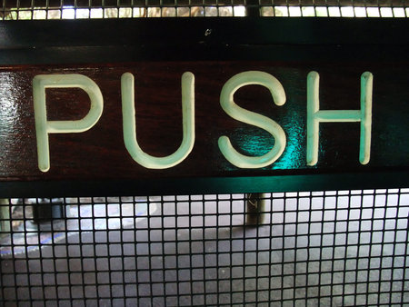 A wooden push sign panel  on door