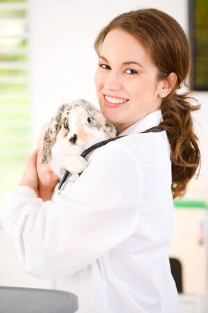 Series set in a Veterinarian's office, with a dog, cat, rabbit and a Caucasian veterinarian and customer.の写真素材