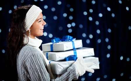 Pretty Caucasian girl in winter clothing on a blue background with glowing white lights.の写真素材