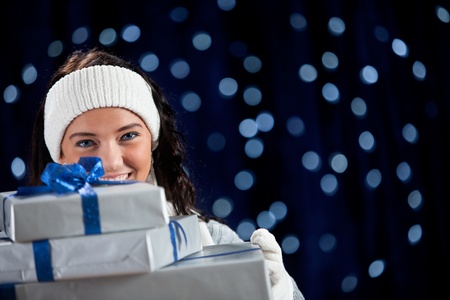 Pretty Caucasian girl in winter clothing on a blue background with glowing white lights.の写真素材