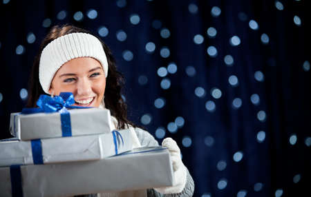 Pretty Caucasian girl in winter clothing on a blue background with glowing white lights.の写真素材