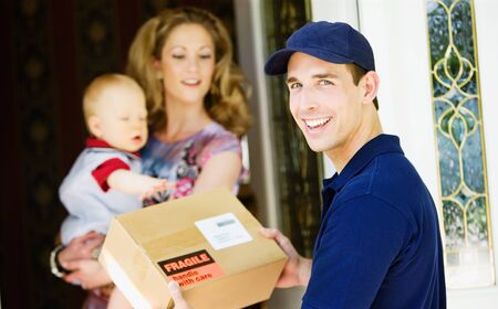 Delivery: Cheerful Man Delivering Package to Homeの写真素材