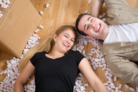 Moving: Couple Laying On Floor Amid Packing Peanuts